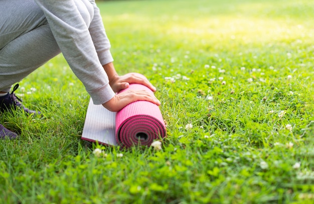 Mujer de primer plano con colchoneta de yoga rosa