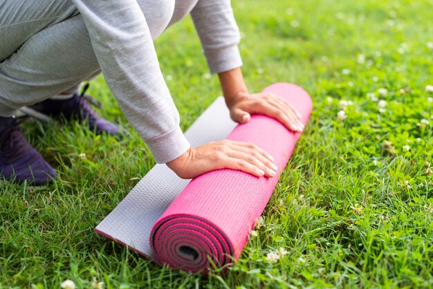 Mujer de primer plano con colchoneta de yoga