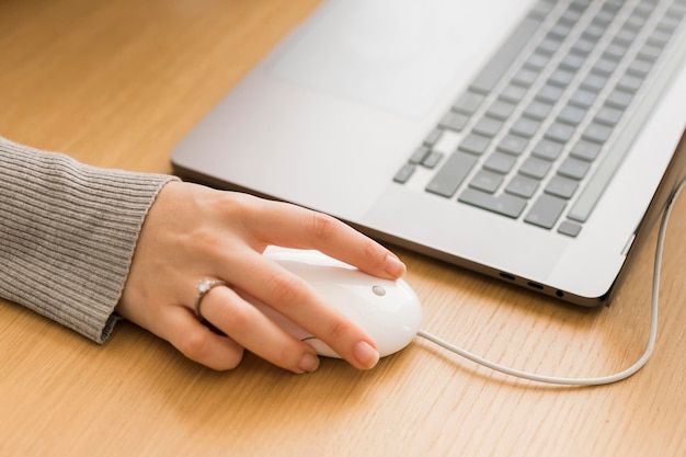 Mujer de primer plano en la computadora portátil con mouse