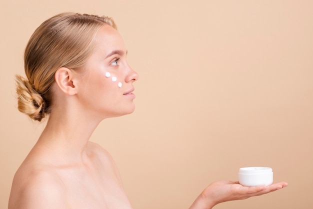 Foto gratuita mujer de primer plano con crema para la cara y tarro