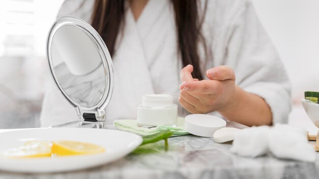 Mujer de primer plano con crema en el dedo