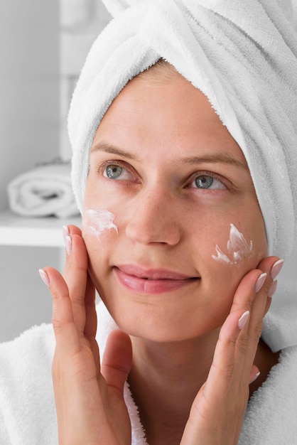 Foto gratuita mujer de primer plano con crema facial