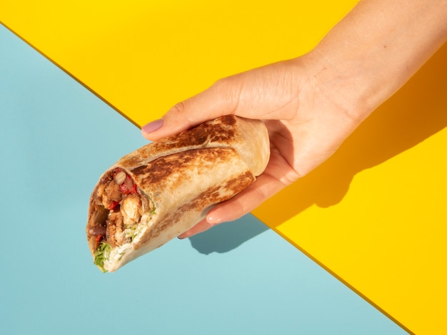 Mujer de primer plano con delicioso burrito y colores de fondo