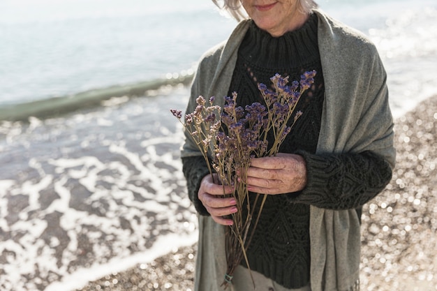 Mujer de primer plano con flores en la playa