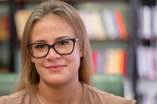 Mujer de primer plano con gafas en la biblioteca