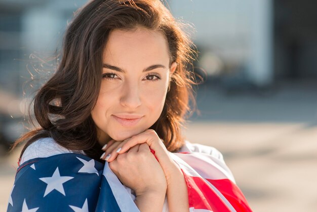 Mujer de primer plano con gran bandera de Estados Unidos