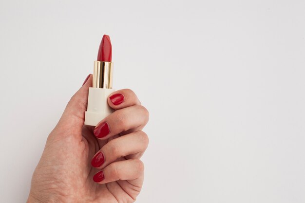 Mujer de primer plano con lápiz labial rojo y fondo blanco.