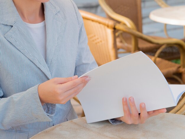 Mujer de primer plano leyendo una revista de maquetas