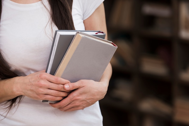 Mujer de primer plano con libros en sus manos