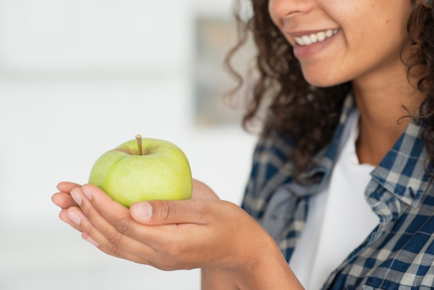 Mujer de primer plano con manzanas verdes