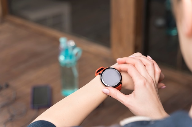 Mujer de primer plano mirando su reloj antes de entrenar