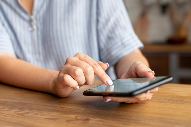 Mujer de primer plano navegando por su teléfono móvil