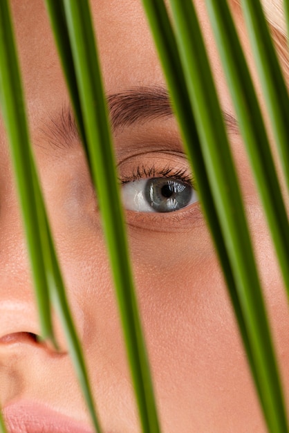 Mujer de primer plano con ojos azules y hojas