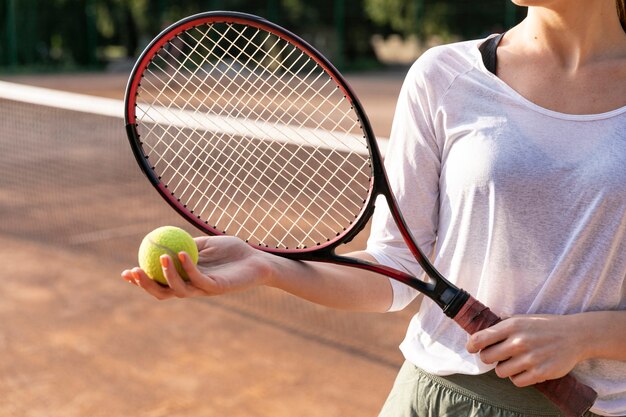 Mujer de primer plano con pelota de tenis