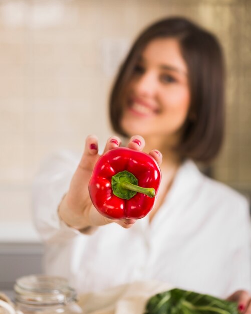 Mujer de primer plano con pimiento orgánico