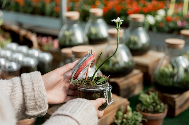 Mujer de primer plano con planta que crece en frasco