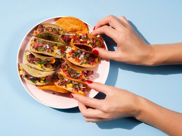 Mujer de primer plano con plato lleno de tacos