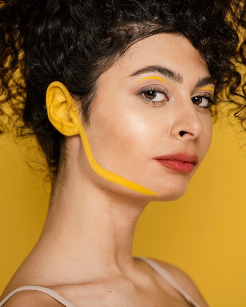 Mujer de primer plano posando con maquillaje amarillo