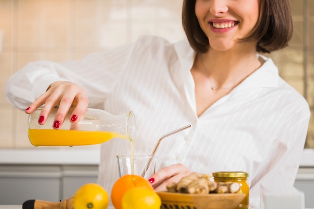 Mujer de primer plano preparando jugo de naranja