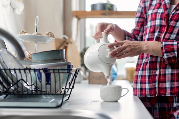 Mujer de primer plano preparando té