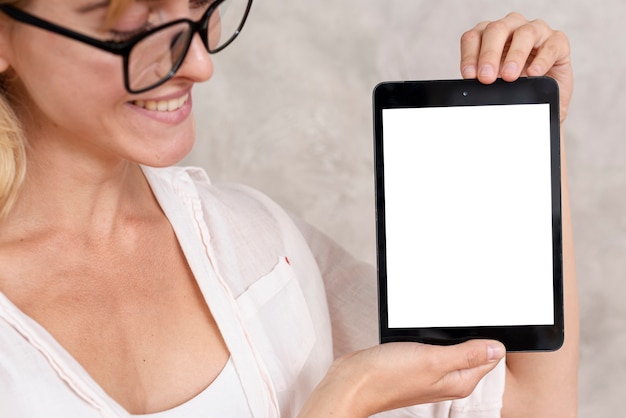 Mujer de primer plano que muestra una tableta con maqueta
