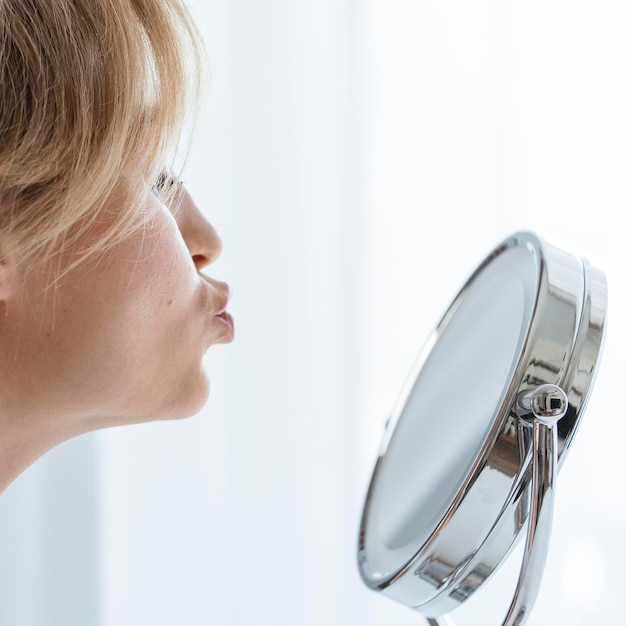 Foto gratuita mujer de primer plano que sopla un beso en el espejo