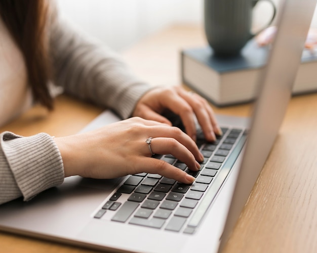 Mujer de primer plano que trabaja en la computadora portátil