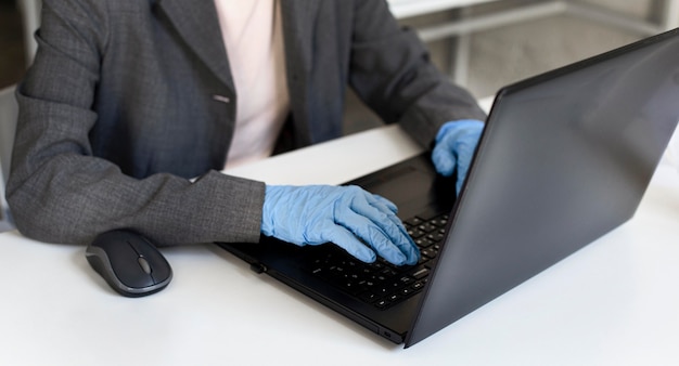 Foto gratuita mujer de primer plano que trabaja en la oficina con guantes quirúrgicos