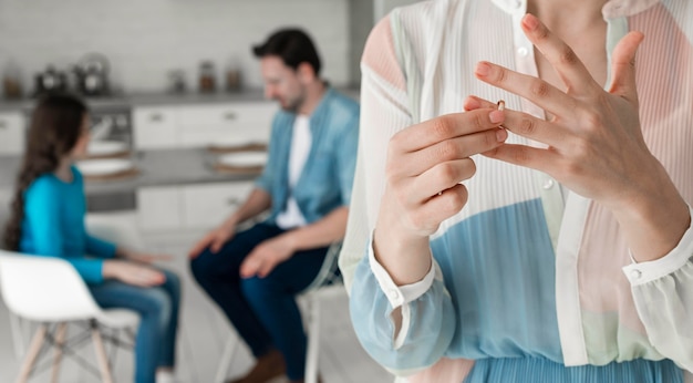 Mujer de primer plano quitándose el anillo de bodas