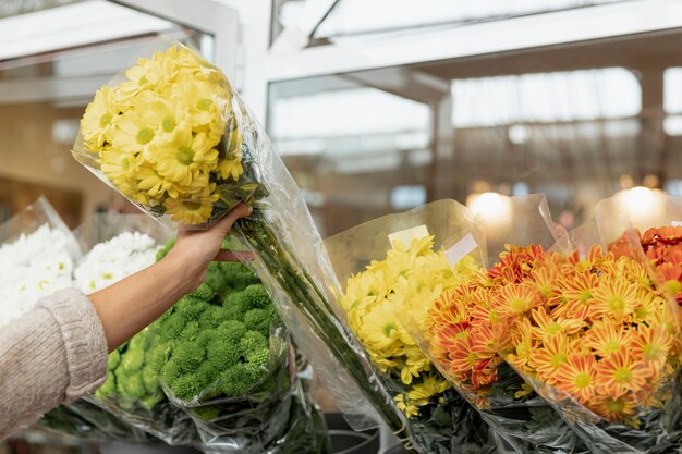 Mujer de primer plano con ramo de flores amarillas