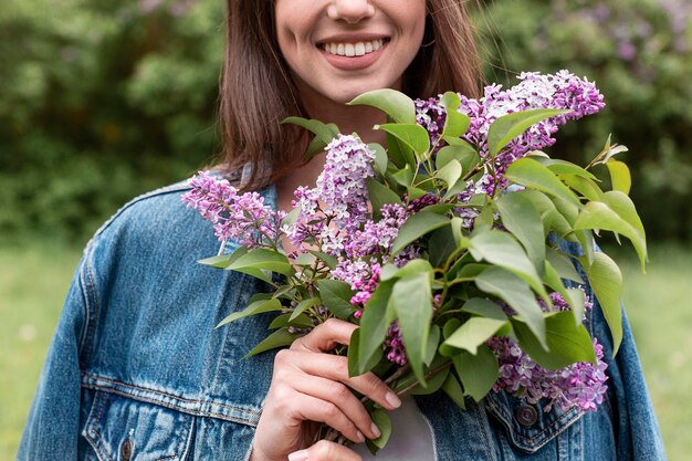 Mujer de primer plano con ramo de flores lila