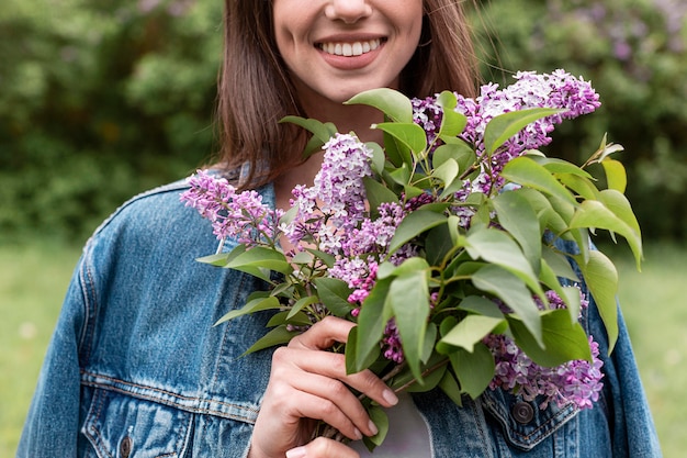 Mujer de primer plano con ramo de flores lila