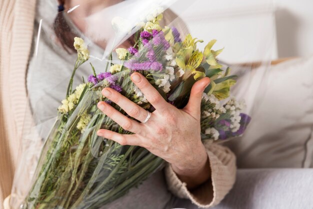 Mujer de primer plano con ramo de flores