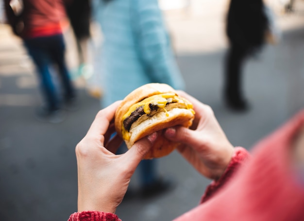 Mujer de primer plano con sabrosa hamburguesa