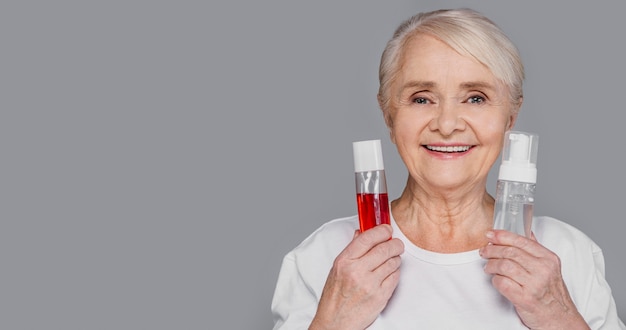 Mujer de primer plano sosteniendo botellas de suero