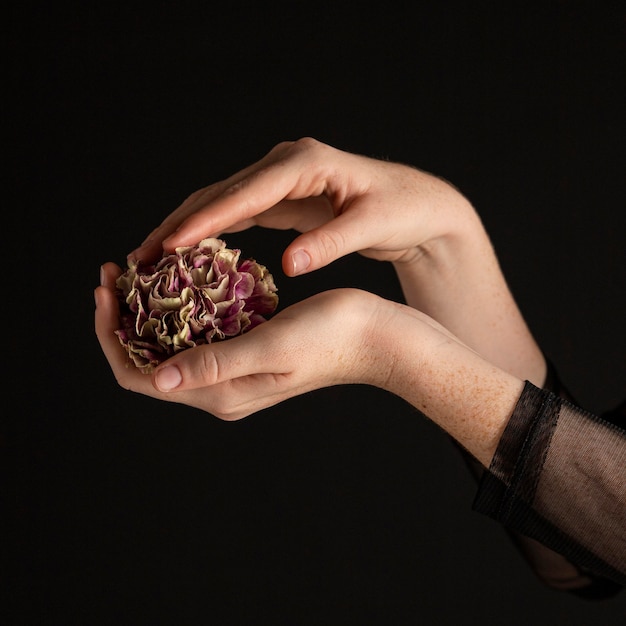 Mujer de primer plano sosteniendo una flor