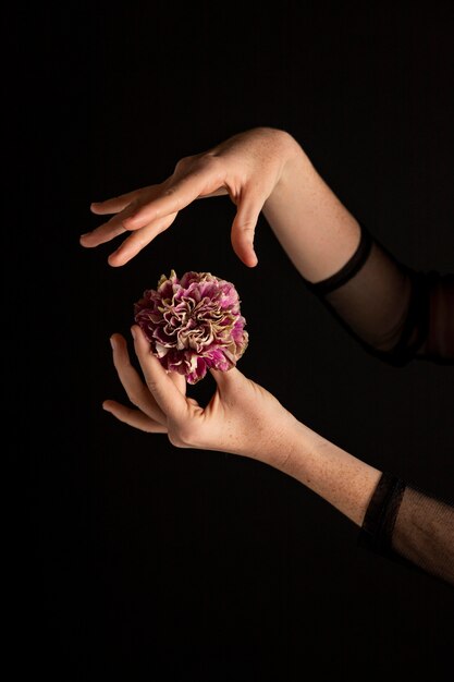 Mujer de primer plano sosteniendo una flor