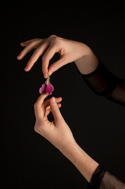 Mujer de primer plano sosteniendo una flor