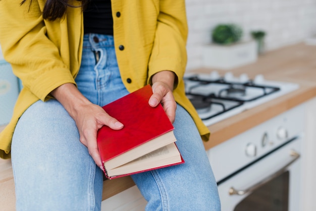 Foto gratuita mujer de primer plano sosteniendo libro con tapa roja