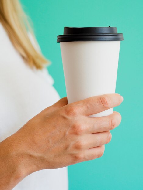 Mujer de primer plano con taza de café y fondo verde