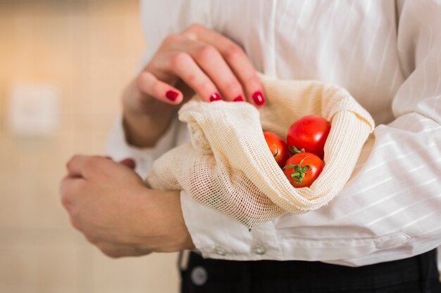 Mujer de primer plano con tomates orgánicos