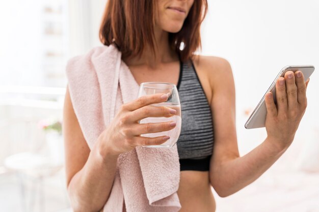 Mujer de primer plano con vaso de agua