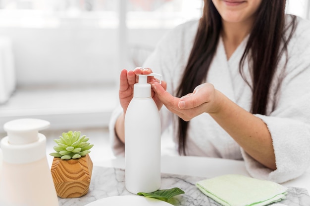 Mujer de primer plano vertiendo crema