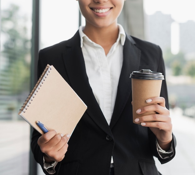 Mujer profesional con bloc de notas y café