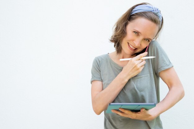 Mujer profesional independiente feliz trabajando con tableta y lápiz