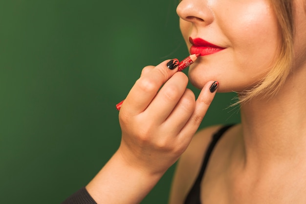Mujer profesional maquillando los labios de una chica