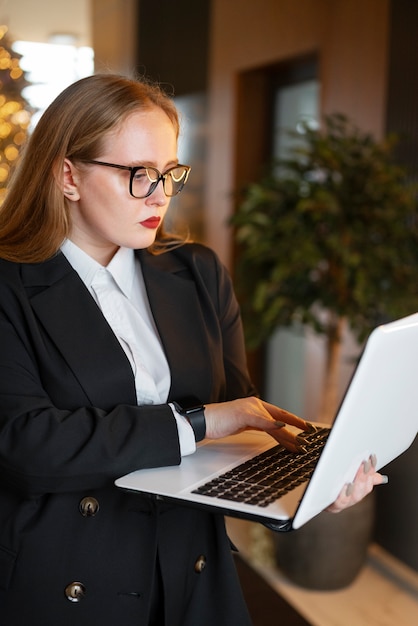 Mujer profesional con traje elegante en la oficina con laptop