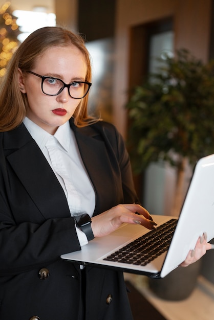 Mujer profesional con traje elegante en la oficina con laptop