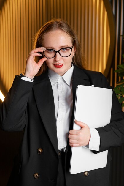 Mujer profesional con traje elegante en la oficina con laptop