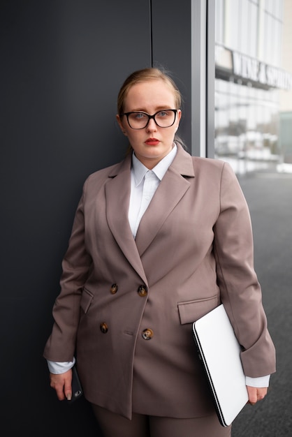 Mujer profesional con traje elegante en la oficina con laptop